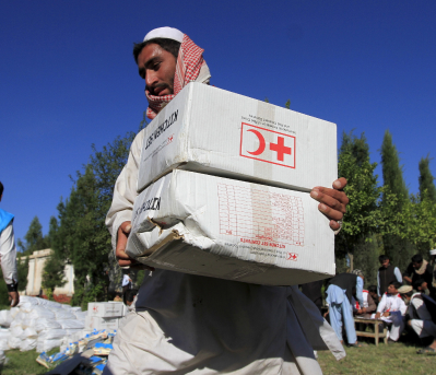 A male holding humanitarian aid boxes.